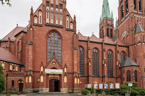 Zewnętrzny portal transeptu oraz kunsztowny szczyt ceglanej świątyni w Rybniku.