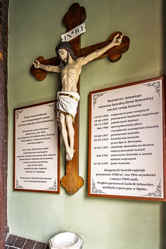 Drewniany krucyfiks oraz tablice historyczne we wnętrzu świątyni w Rybniku.