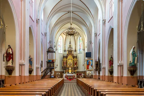 Nawa główna rędzińskiego kościoła z rzędami ław sklepieniem krzyżowym i ołtarzem głównym.