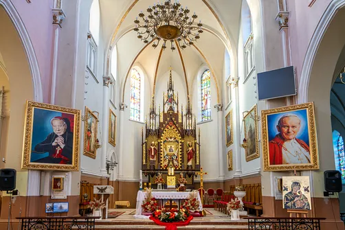 Ołtarz główny kościoła w Rędzinach oraz portrety kardynała Wyszyńskiego i papieża Jana Pawła II.