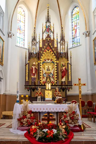 Neogotycka nastawa ołtarza głównego z figurami świętych w prezbiterium rędzińskiej świątyni.