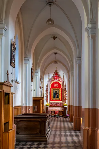 Przesklepiona nawa boczna świątyni zamknięta ołtarzem z ikoną Matki Bożej.