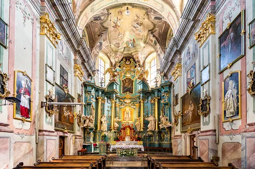 Presbiterium przemyskiej świątyni z barokowym ołtarzem głównym i obrazami na ścianach.