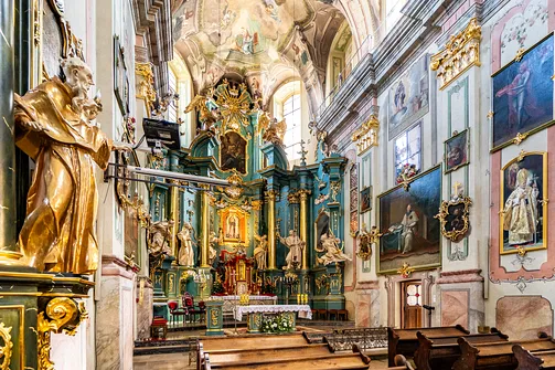 Boczne ujęcie prezbiterium w przemyskim kościele św. Marii Magdaleny z polichromią i ołtarzem.