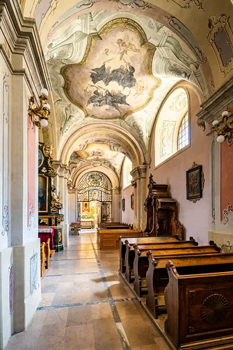 Freski i drewniane ławki w nawie bocznej kościoła św. Marii Magdaleny w Przemyślu.