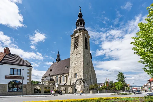 Kamienna wieża z hełmem oraz nawa główna limanowskiej bazyliki.