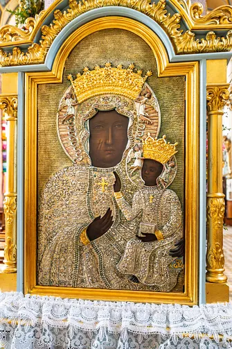 Kopia obrazu Matki Bożej Częstochowskiej w złoconej ramie ołtarzowej.