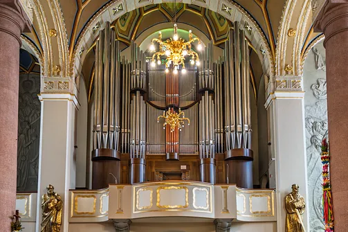 Prospekt organowy na emporze chórowej limanowskiego sanktuarium ze złoconą balustradą.
