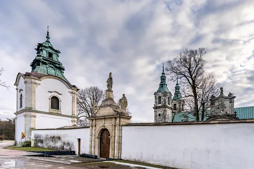 Barokowa dzwonnica oraz brama z rzeźbami w murze ogrodzeniowym opactwa w Jędrzejowie.
