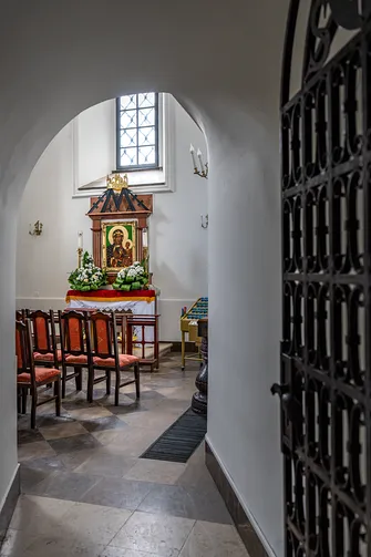 Widok przez portal z kratą na wnętrze kaplicy z obrazem Matki Bożej w Jędrzejowie.
