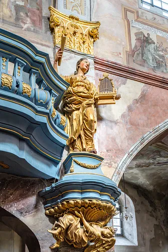 Złocona rzeźba św. Cecylii przy barokowym prospekcie organowym w bazylice jędrzejowskiej.