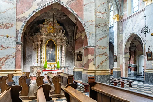 Architektura nawy z ostrołukową arkadą i ołtarzem bocznym w świątyni opackiej w Jędrzejowie.