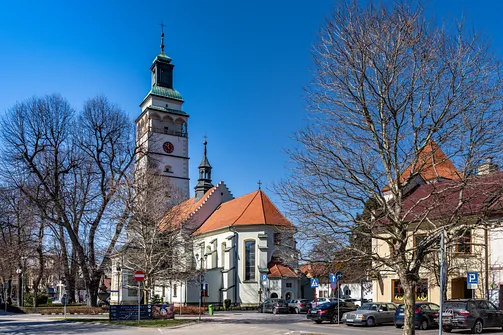 Widok z zewnątrz na bryłę żywieckiej konkatedry z wieżą i nawą główną.