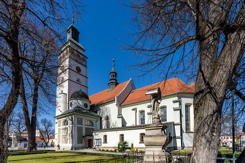 Elewacja boczna świątyni w Żywcu z widoczną kaplicą i rzeźbą w otoczeniu.