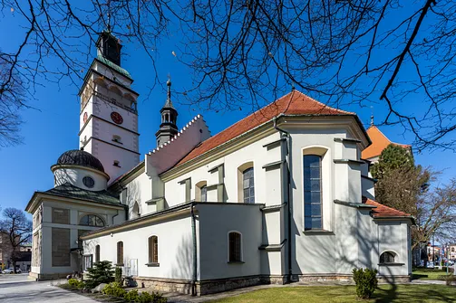 Szkarpowane ściany zewnętrzne żywieckiej świątyni z półkolistymi oknami nawy.