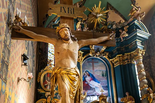Drewniany krucyfiks na tle prezbiterium żywieckiej fary.