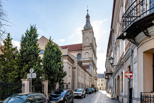 Perspektywa ulicy prowadząca w stronę barokowej wieży kościoła oo. Pijarów.