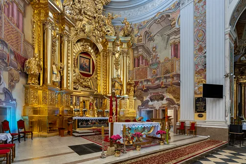 Prezbiterium kościoła z barokową nastawą ołtarzową oraz malowidłami ściennymi.