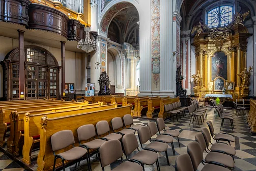 Nawa główna sanktuarium z ławkami, chórem muzycznym i ołtarzem bocznym.